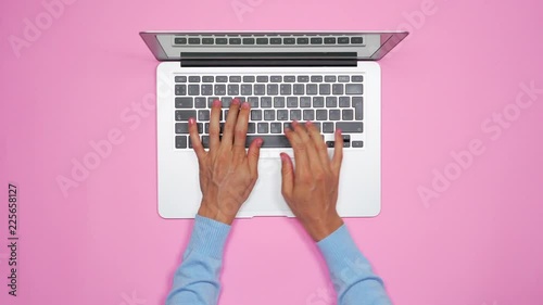 Woman hands typing on keyboard of silver laptop photo