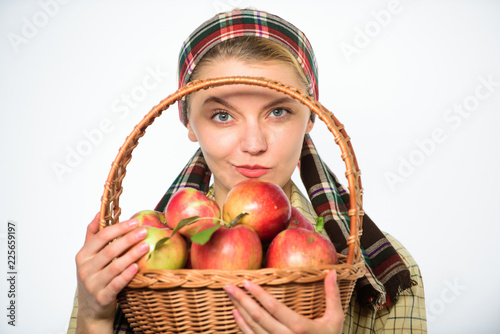 Woman cheerful villager carry basket with natural fruits. Lady farmer gardener proud of her harvest. Woman gardener rustic style hold basket with apples on white background. Harvesting time concept photo