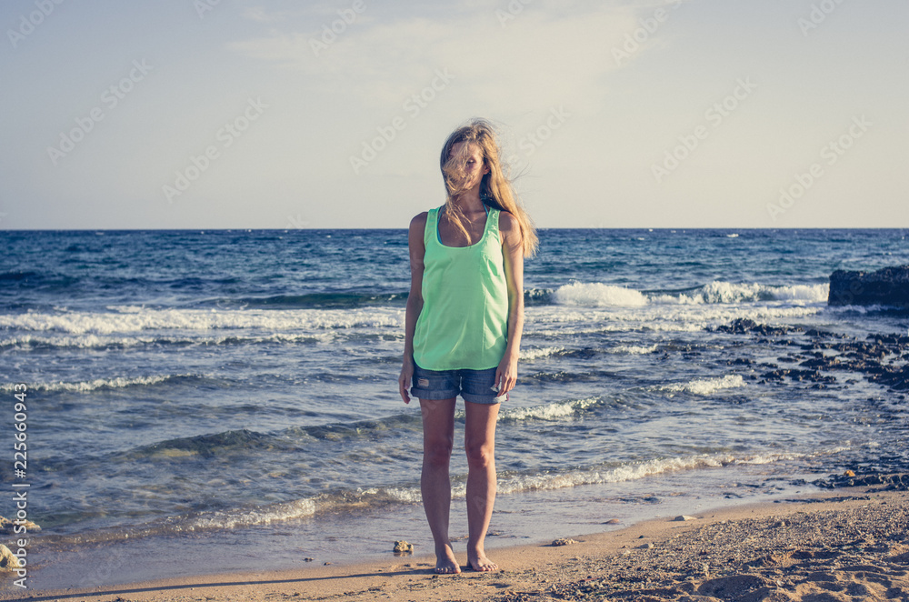 A woman with her hair loose in the wind on the background of the sea A woman with her hair loose in the wind on the background of the sea