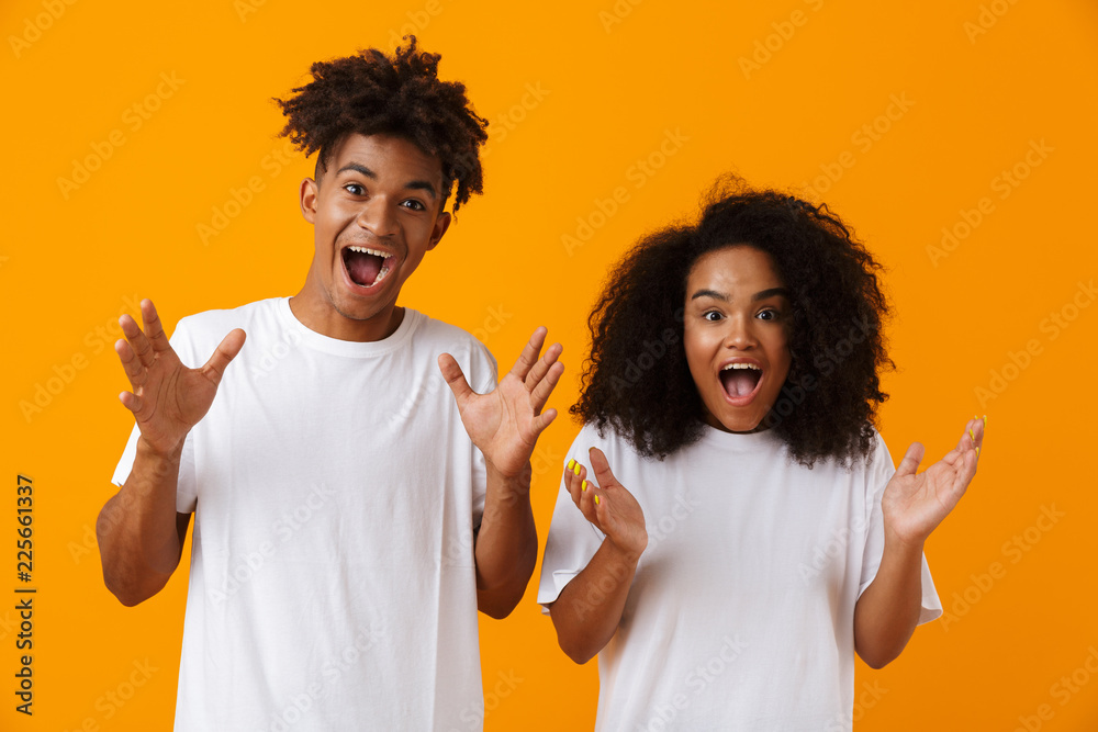 Emotional young cute african couple posing isolated over yellow background. Emotional young cute african couple posing isolated over yellow background.
