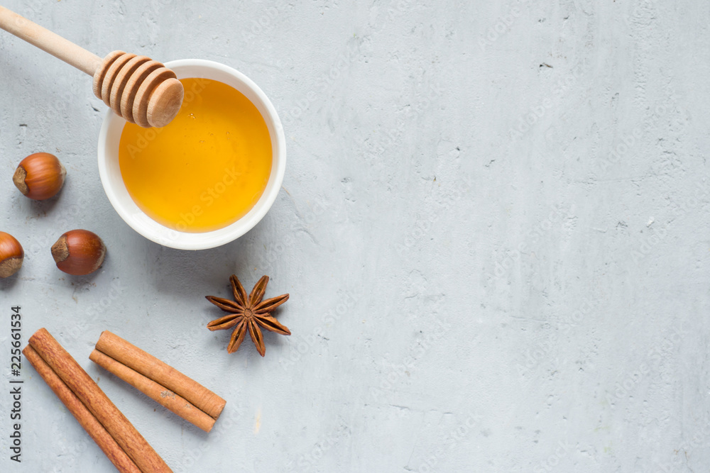 Fototapeta premium Honey liquid and anise with cinnamon on a light background. Copy space for text.
