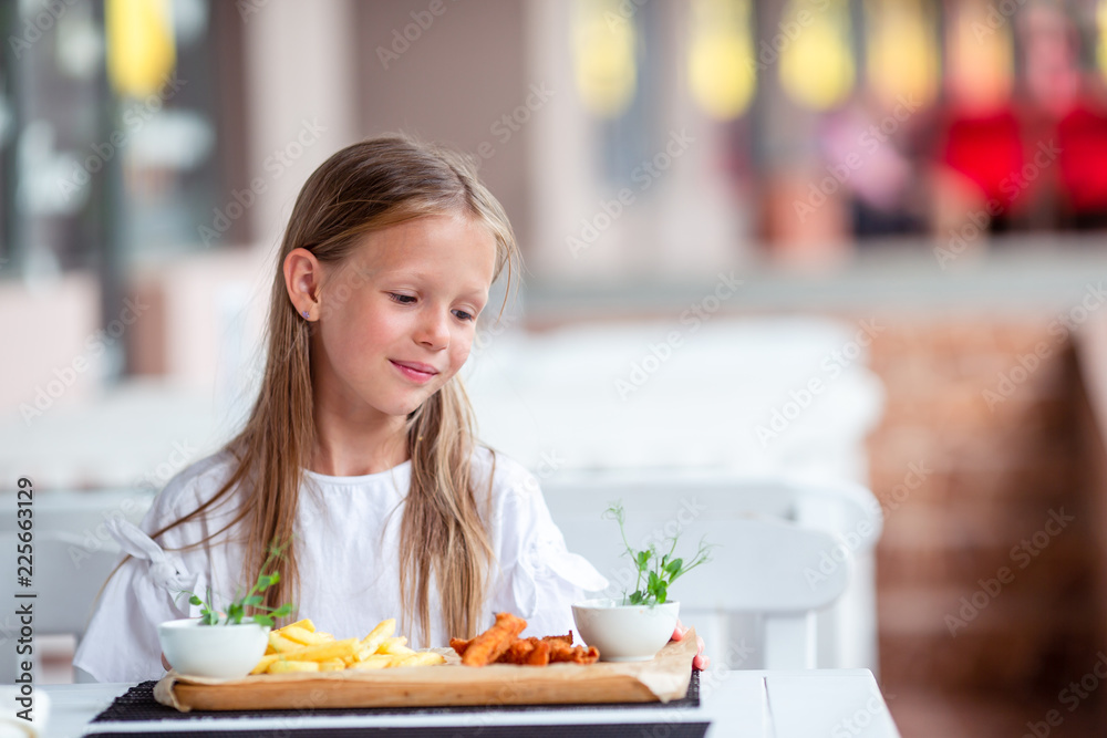 Adorable little girl having lunch at outdoor cafe Adorable little girl having lunch at outdoor cafe