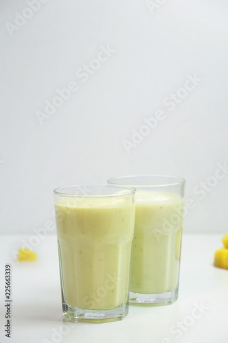 Healthy mango smoothie in a glass on a white background