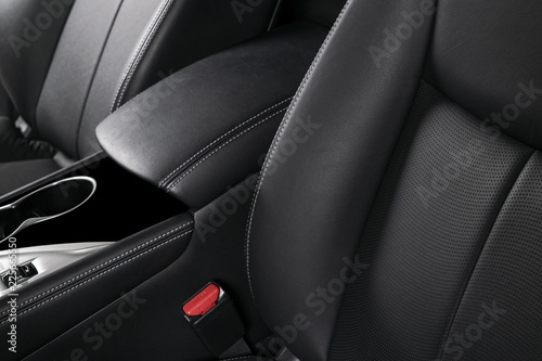 Modern luxury car black leather interior. Part of leather car seat details with stitching. Interior of prestige car. Comfortable perforated leather seats. Black perforated leather. Car detailing © Aleksei
