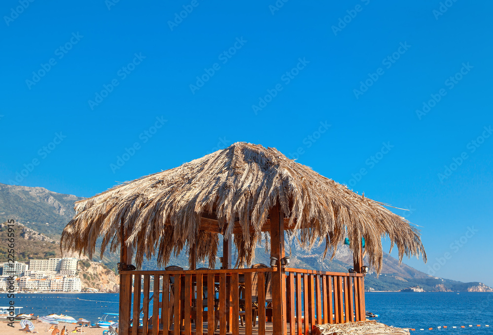 Fototapeta premium exotic gazebo covered by straw on the sunny beach 