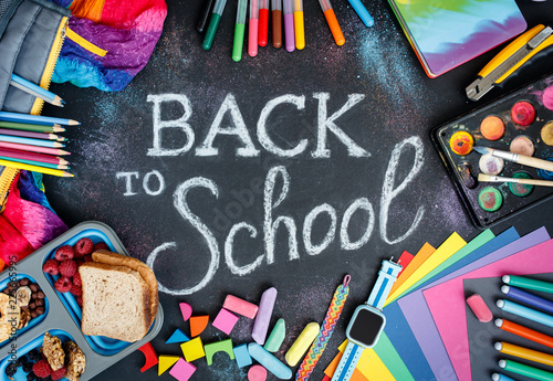 A bunch of various colorful school and art supplies with chalk lettering. Top view.
