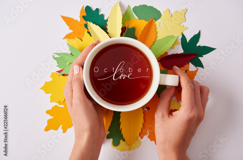 partial view of woman holding cup of hot tea with 