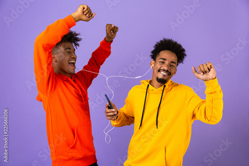 Two joyful african man friends dressed in colorful hoodies