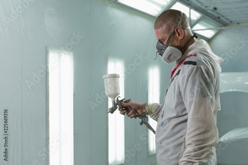 Male mechanic using spray paint