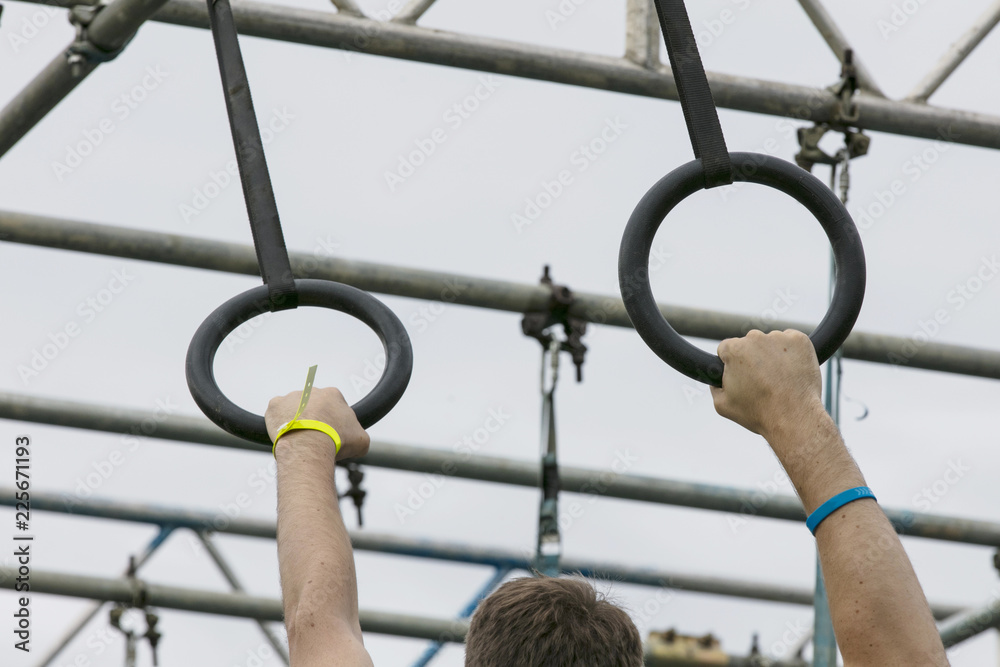 A person on hanging rings during an adventure obstacle course race