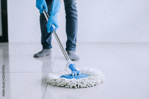 Fotografie Husband housekeeping and cleaning concept, Happy young man in blue rubber gloves