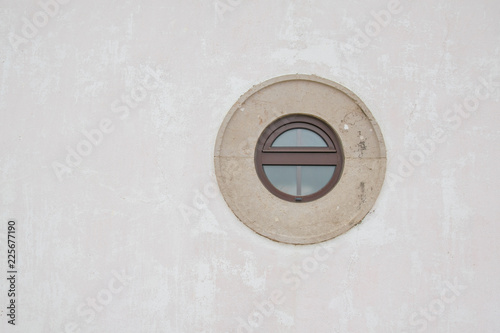 An old circular window on white  wall