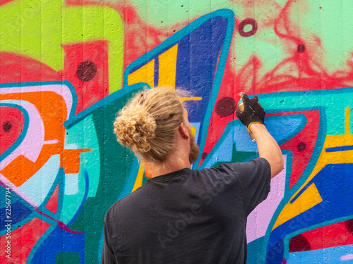 young man use his talent and feeling for art to apply this with various colors to a city wall
