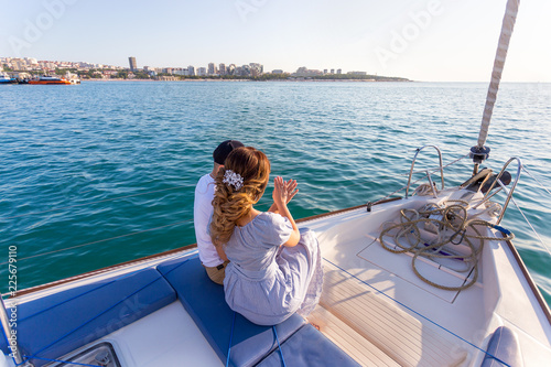 Happy bride and groom hugging on a yacht © yana_vinnikova