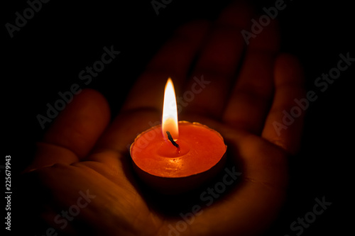 Burning candle on the palm
