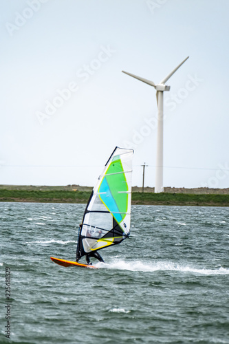 Man windsurfing close to the town of Caernarfon in Wales - United Kingdom
