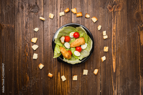 Caesar salad with chicken, cherry tomatoes and quail eggs on a plate