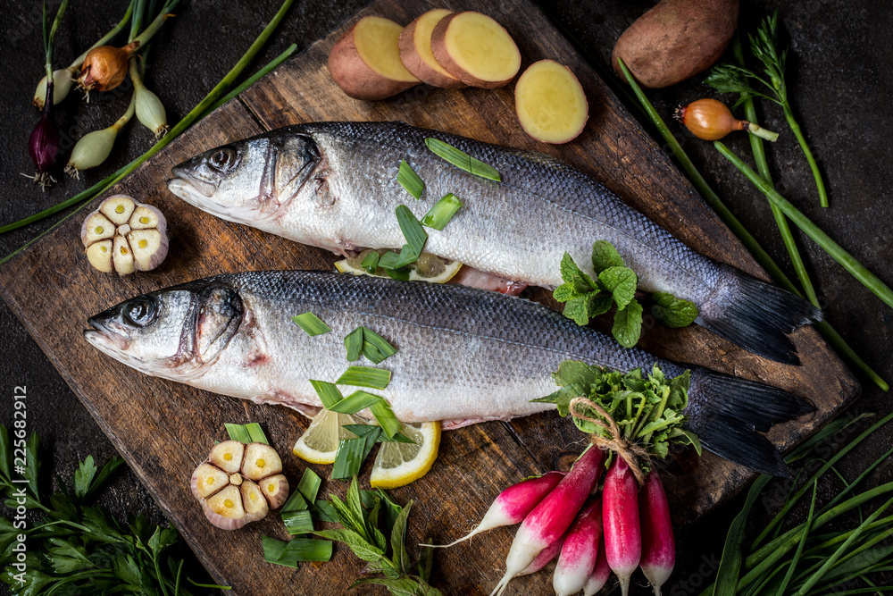 fish sea bass with vegetables potatoes, garlic and herbs, ingredients for cooking fish sea bass with vegetables potatoes, garlic and herbs, ingredients for cooking