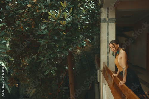 Pretty young woman standing in hotel balcony, looking out enjoyi photo