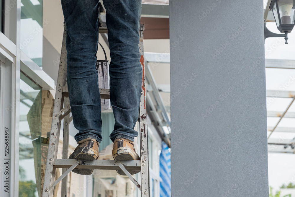 Fototapeta premium Construction worker standing on aluminium stairs