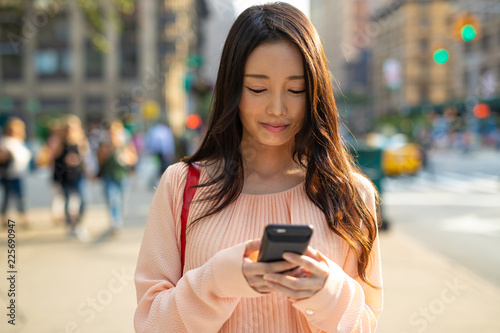 Canvas Print Asian woman in city walking using cell phone smile happy