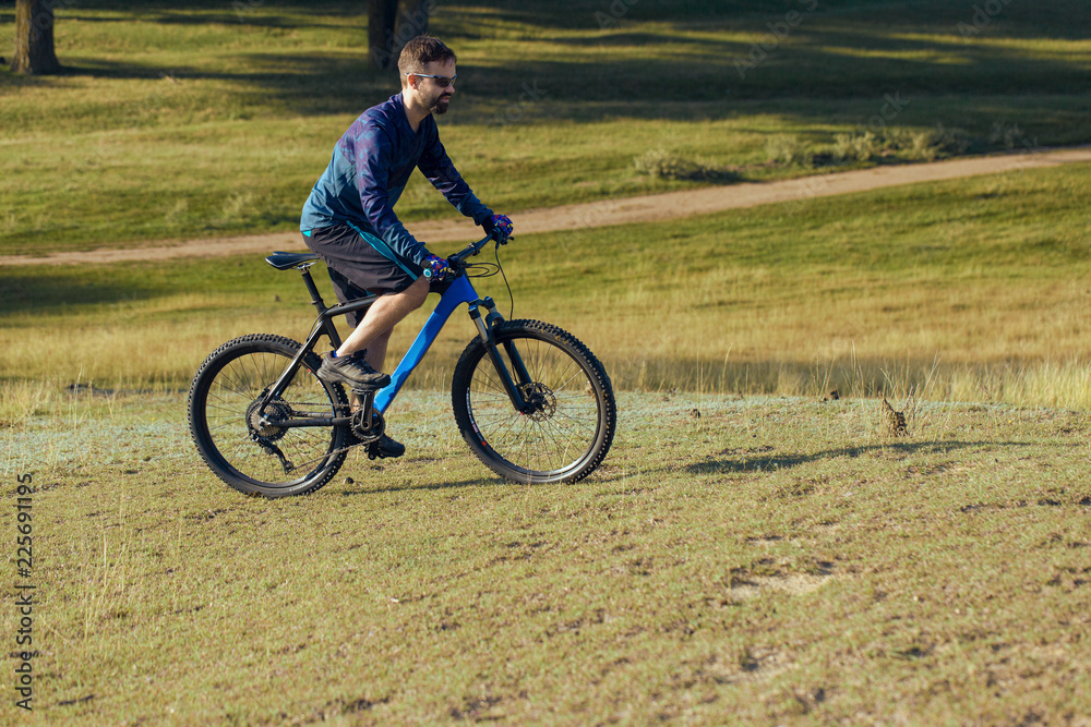 A cyclist rides the hills, Beautiful portrait of a guy on a blue bicycle