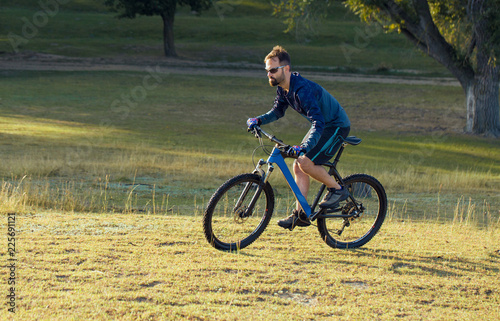 A cyclist rides the hills, Beautiful portrait of a guy on a blue bicycle