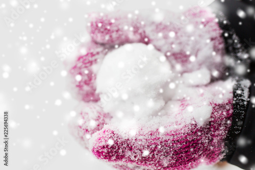 winter holidays, christmas and people concept - close up of woman holding snowball outdoors