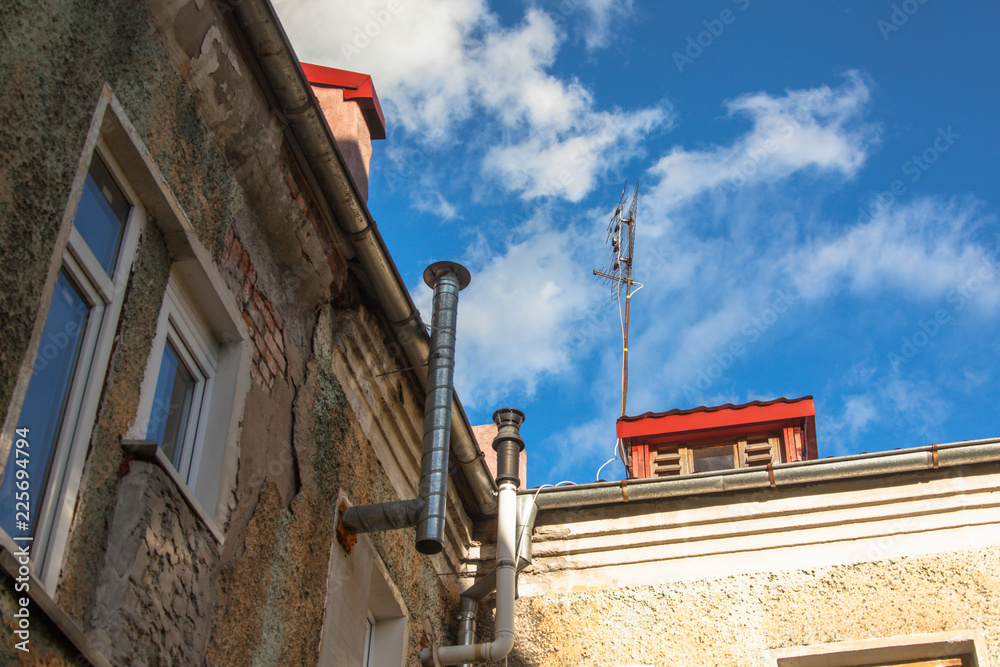 Obraz premium walls and roof of an old house, blue sky in the background, view from below