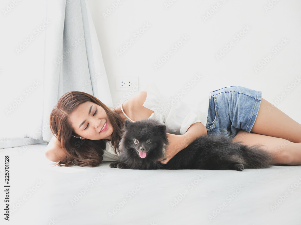 Asian woman playing with little dog black color in living room lifestyle girl with pet Asian woman playing with little dog black color in living room lifestyle girl with pet