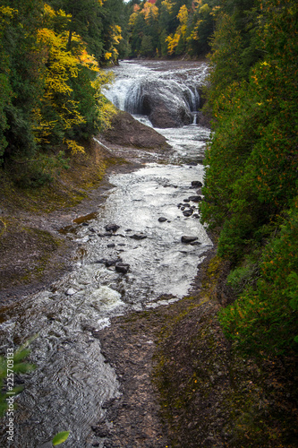 Michigan Autumn Waterfall. Potawatomi Falls in the Ottawa National Forest in the Upper Peninsula of Michigan. Shot in vertical orientation and surrounded by beautiful fall foliage. photo
