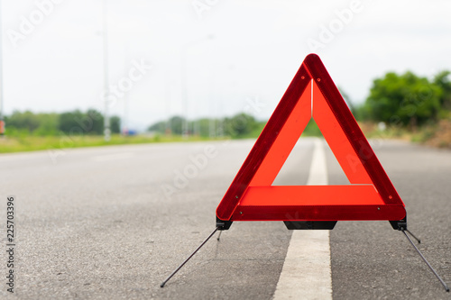 breakdown triangle symbol stands near broken car alongside the road. Car broke down on the road. Broken car accident sign on a road concept. photo