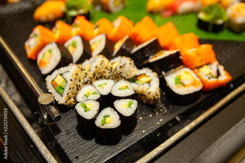 Assortment of tasty and delicious Sushi. Most popular Japanese food. Maki Sushi is vinegared rice and raw fish or seafood wrapped in seaweed. Healthy eating and eat well concept.
