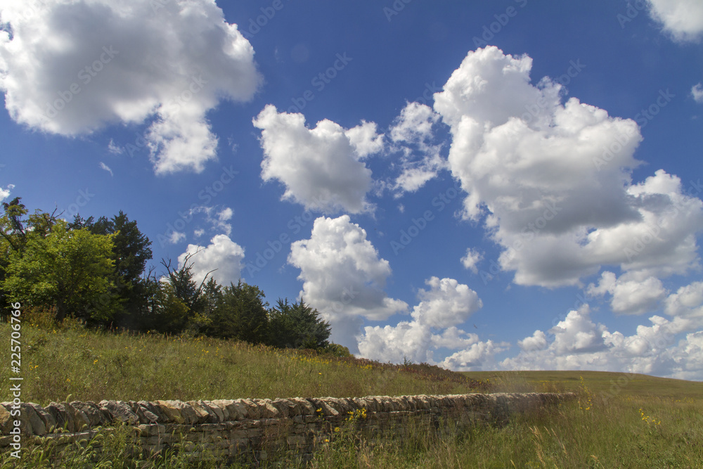 limestone wall, cumulus clouds in blue sky, Tallgrass Prairie National Preserve, Kansas