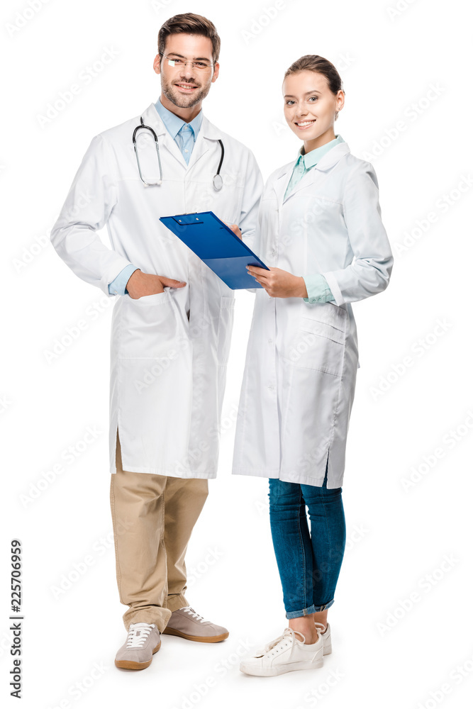 happy female doctor holding clipboard while her male colleague standing near isolated on white happy female doctor holding clipboard while her male colleague standing near isolated on white