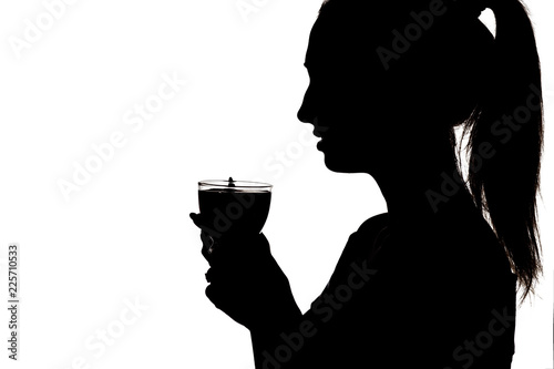 silhouette of girl drinking tea, femali holding ih hands cup with hot beverage, woman face profile on a white background photo