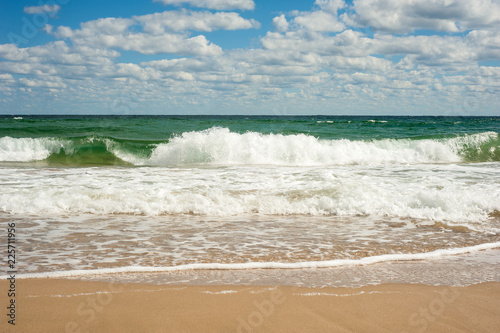 Big breaking Sea wave on a sandy beach on the shore of Sozopol in Bulgaria. Beautiful waves wash the beach with golden sand on a bright summer day.