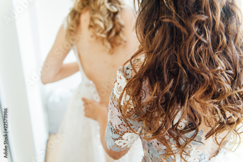 Gorgeous, blonde bride in white luxury dress is getting ready for wedding. Morning preparation