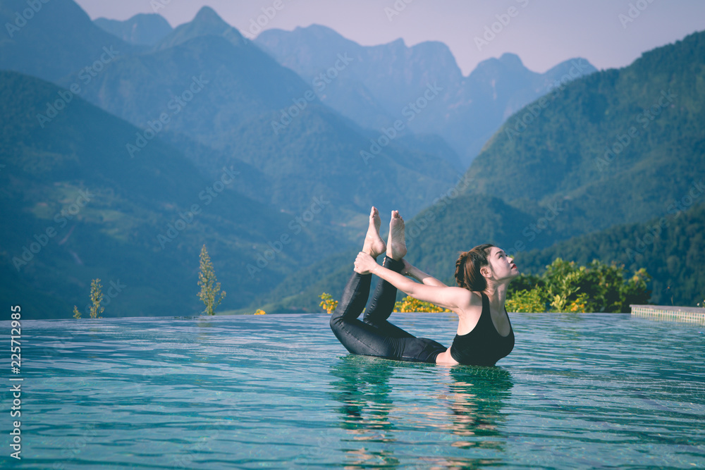 © 220 Selfmade studio - Beautiful Attractive Asian woman practice yoga bow or dhanurasana pose on the pool above the Mountain peak in the morning in front of beautiful nature views in SAPA vietnam,Feel so comfortable © 220 Selfmade studio - Beautiful Attractive Asian woman practice yoga bow or dhanurasana pose on the pool above the Mountain peak in the morning in front of beautiful nature views in SAPA vietnam,Feel so comfortable