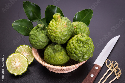 Bergamot, kaffir lime and kaffir lime leaf with basket and knife  on dark background photo