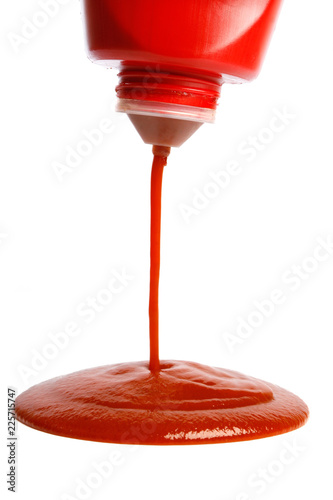 pouring ketchup from bottle on white background