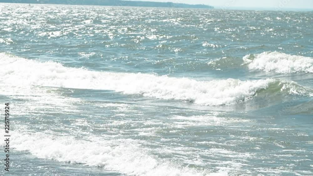 The waves surging on the sandy shore. Waves hitting the shore. Beauty waves splashing on river coast. Sea waves hitting the coast, slow motion The waves surging on the sandy shore. Waves hitting the shore. Beauty waves splashing on river coast. Sea waves hitting the coast, slow motion