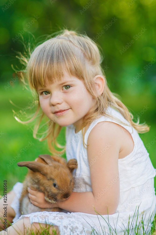 Girl with a cute little rabbit, outdoor, summer day Girl with a cute little rabbit, outdoor, summer day