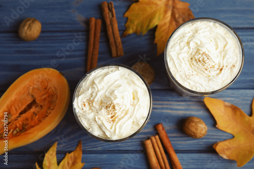 Flat lay composition with tasty pumpkin spice latte on wooden table