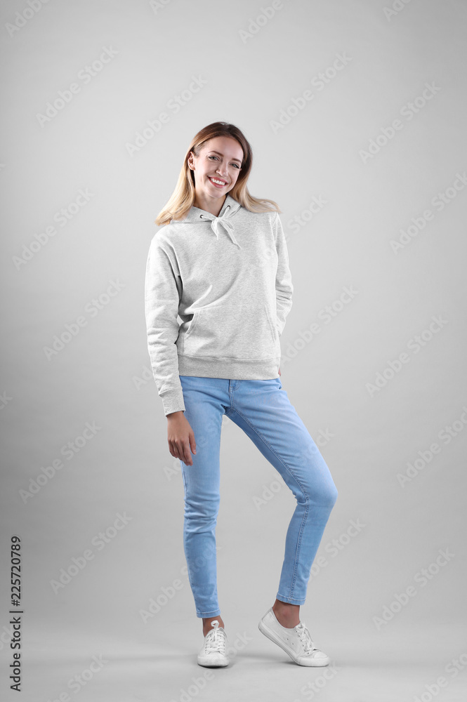 Full length portrait of woman in hoodie sweater on light background. Space for design Full length portrait of woman in hoodie sweater on light background. Space for design