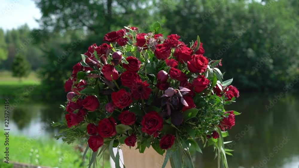 Red roses flowers beautiful composition bouquets at wedding ceremony at countryside at summer sunny day Red roses flowers beautiful composition bouquets at wedding ceremony at countryside at summer sunny day