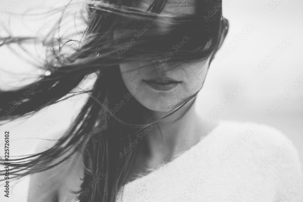 Junge, brünette Frau am Strand - Wind in den Haaren Junge, brünette Frau am Strand - Wind in den Haaren