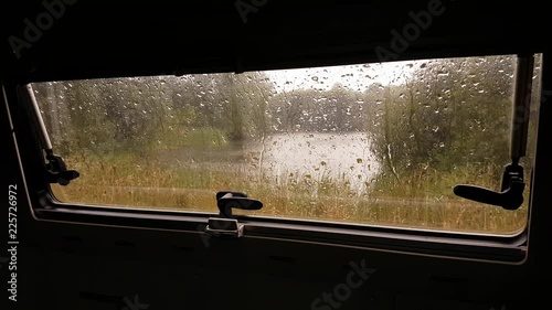 Pouring rain seen through a motorhome caravan window.