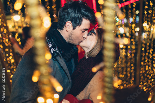 Canvas Print Beautiful young couple in love enjoying Christmas or New Year night on a city street