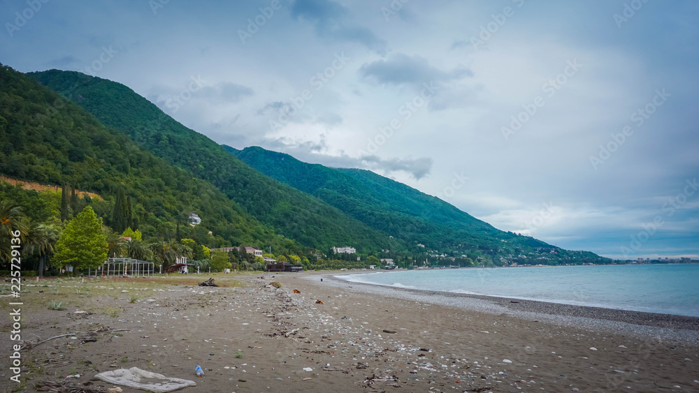 Beach after a storm on the background of green mountains in Abkhazia